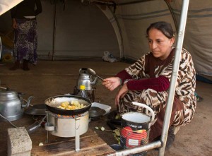 A Yazidi woman cooks a meal in the refugee camp (Photo: Nick Ashdown/The Media Line)