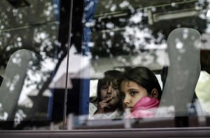 Refugee children look through a bus window as they leave for Istanbul while waiting to cross to Europe near Turkey’s western border with Greece and Bulgaria, in Edirne, on September, 23, 2015. Hundreds of migrants have made the trek to Edirne in the hope of being allowed to cross into neighboring Greece or Bulgaria and avoid the often-risky journey across the Aegean Sea. Many arrived last week but have been blocked from approaching the border by law enforcement. (Photo: STR/AFP/Getty Images)