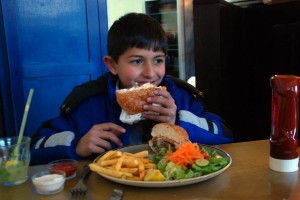 Aziz Alyan, 8, enjoying a Sarwa burger alongside his dad.