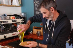 Shimon Cohen pouring locally sourced olive oil on salad. 